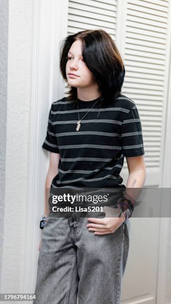 transgender non binary teenager in relaxed clothes candid indoor portrait - androgynous stock pictures, royalty-free photos & images