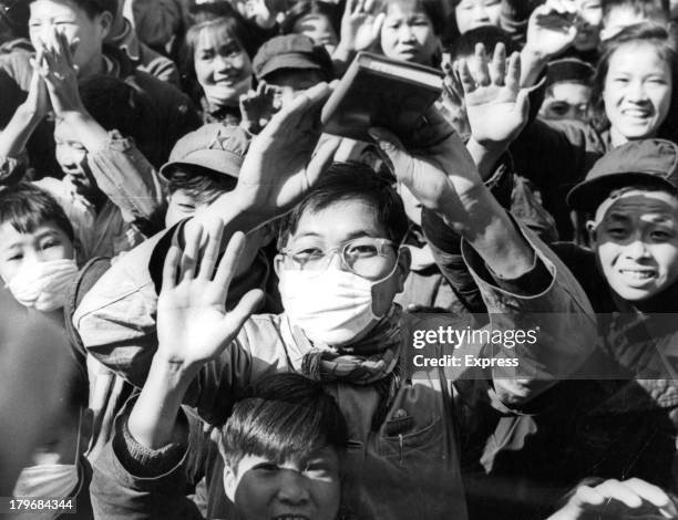 Young Red Guards acclaim the thought of Mao. One boy wears a mask as he waves his book of Mao's Thoughts in Beijing, China.