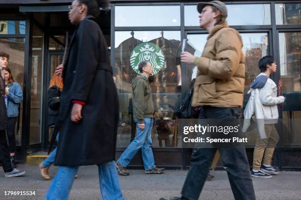 People picket outside of a Starbucks store in New York's East Village as Starbucks Workers United have announced that they are waging the company's...