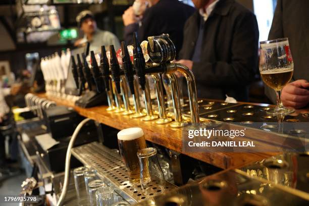 Freshly poured pint of lager is pictured as drinkers enjoy their beers at a pub in central London on November 22, 2023. Britain's Conservative...