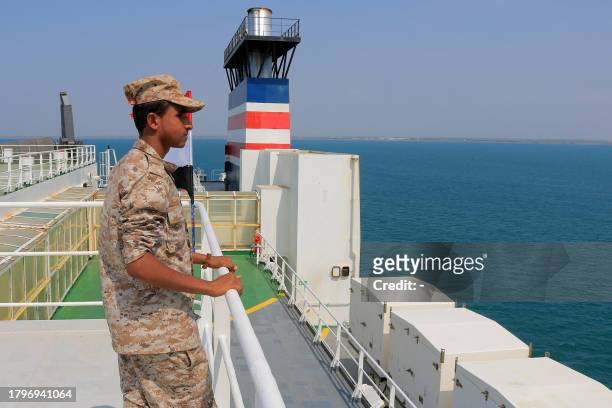 Picture taken during an organised tour by Yemen's Huthi rebels on November 22, 2023 shows a security guard aboard the Galaxy Leader cargo ship,...
