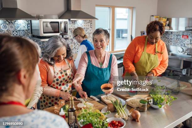 un travail d’équipe pour préparer un repas - cours de cuisine photos et images de collection