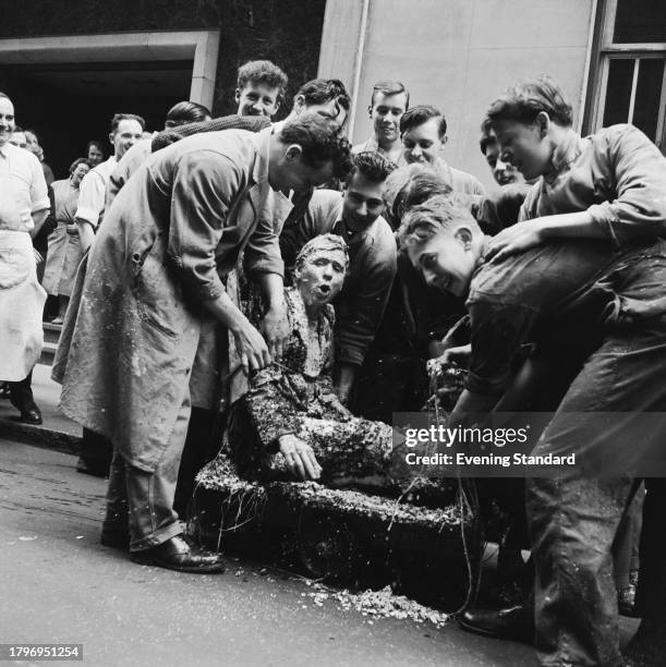 Group of teenage boys during a traditional 'Banging Out' ceremony celebrate the completion of an apprenticeship in the printing industry of a worker...