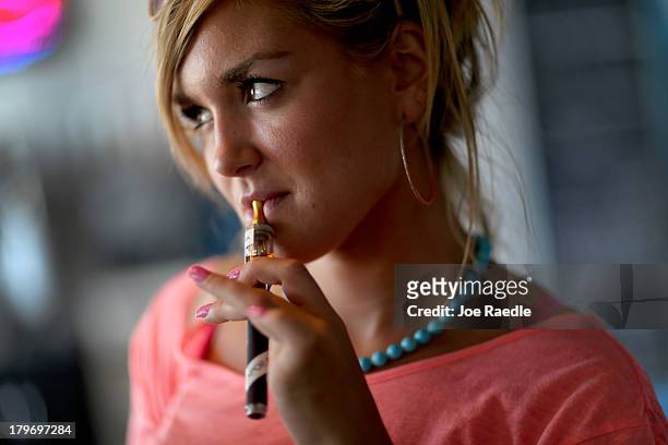 Chloe Lamb enjoys an electronic cigarette at the Vapor Shark store on September 6, 2013 in Miami, Florida. E-cigarette manufacturers have seen a...