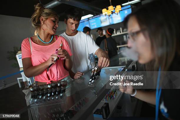 Chloe Lamb and Jacob Knight shop for an E liquid flavor for her electronic cigarette at the Vapor Shark store on September 6, 2013 in Miami, Florida....