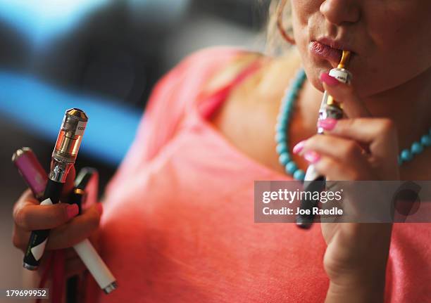Chloe Lamb tries a flavor of E liquid in her electronic cigarette as she shops for a flavor at the Vapor Shark store on September 6, 2013 in Miami,...