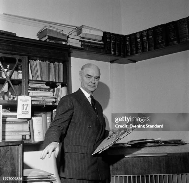 Businessman and head of Decca records Edward Lewis in his office holding vinyl records, May 17th 1957.