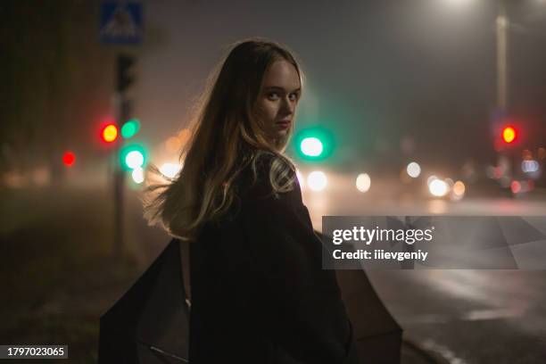 frau auf nächtlichem stadtstraßenhintergrund. - doom patrol stock-fotos und bilder