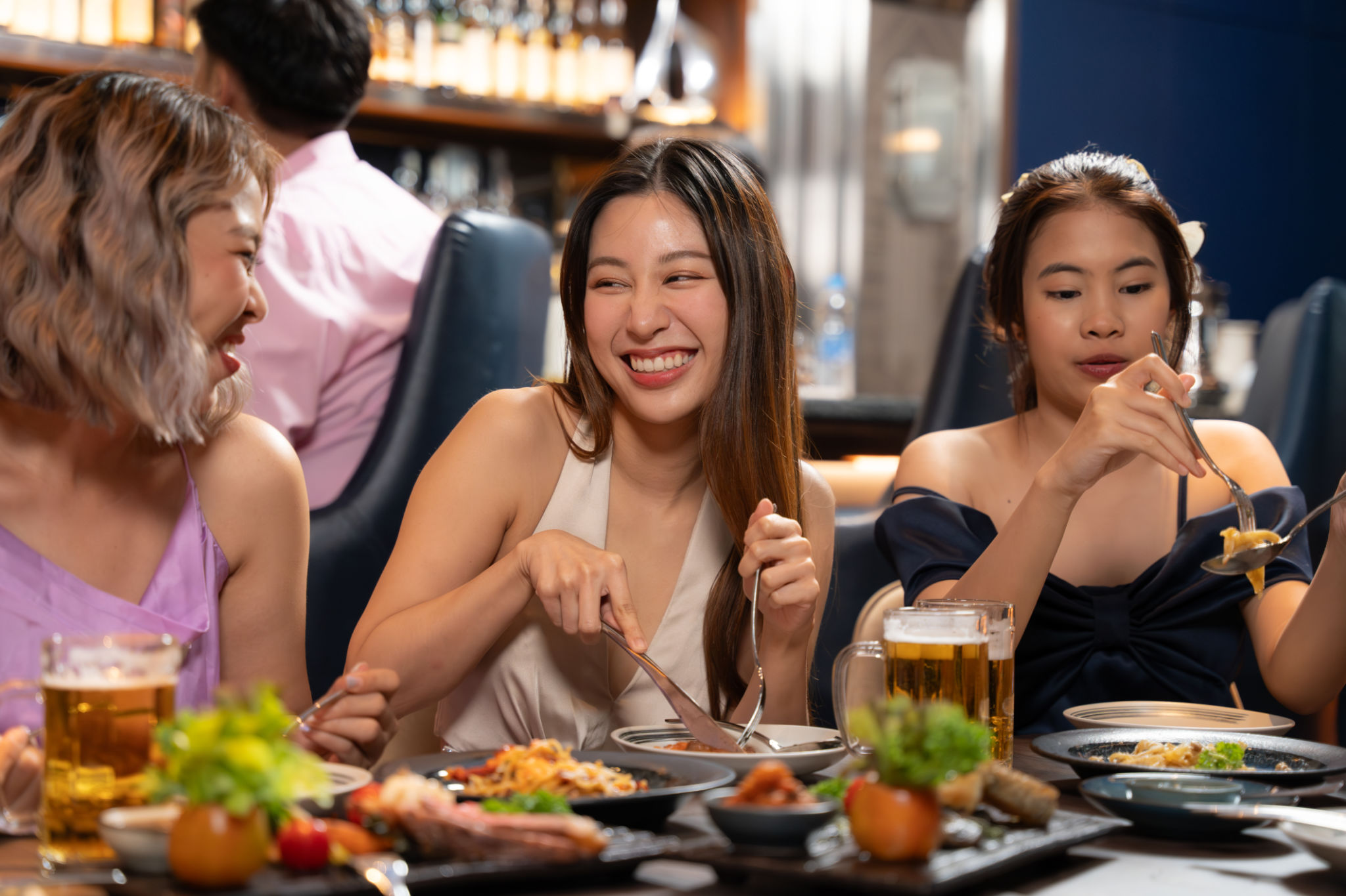 Beautiful Asian woman is Relishing a Delightful Dinner with Friends. Beautiful Asian woman is Relishing a Delightful Dinner with Friends.