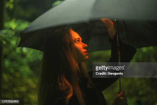 woman with umbrella at night. - mysterious blond woman stock pictures, royalty-free photos & images
