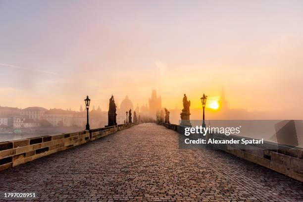 charles bridge and prague old town skyline at sunrise in autumn, czech republic - prag stock-fotos und bilder