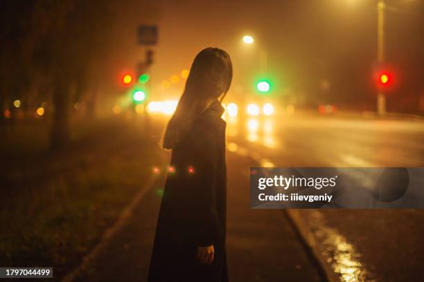 woman on night city street background. - bang stockfoto's en -beelden
