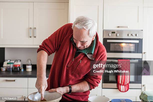 senior male using wooden spoon in mixing bowl - mixing bowl stock pictures, royalty-free photos & images