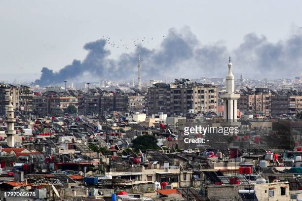 Smoke billows above buildings after an Israeli strike on the outskirts of Damascus on November 22, 2023. Syria's two main airports are still shut a...