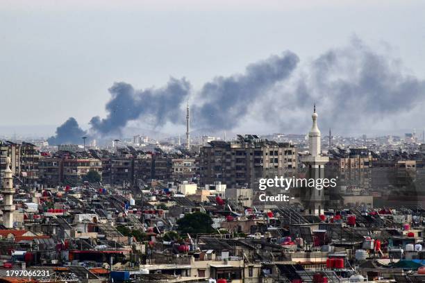 Smoke billows above buildings after an Israeli strike on the outskirts of Damascus on November 22, 2023. Syria's two main airports are still shut a...