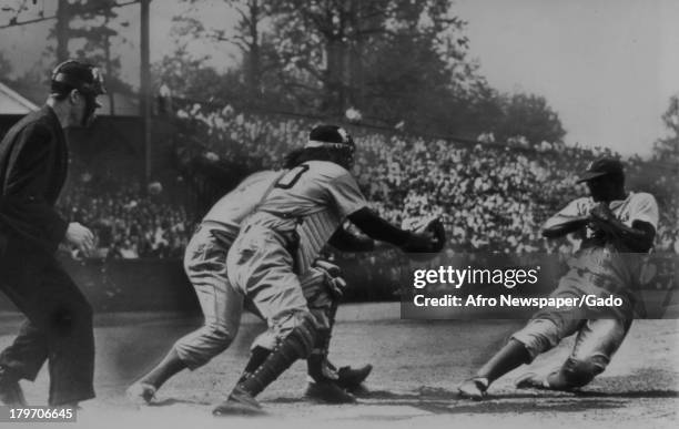 American baseball player Jackie Robinson of the Brooklyn Dodgers stealing home base during game with Arizona Crackers during the second inning, 1948.
