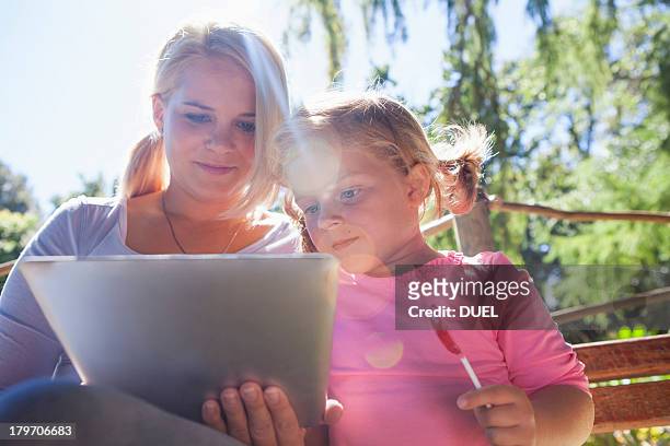 mother using laptop, girl with lollipop - girl lollipops stock pictures, royalty-free photos & images