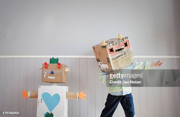 boy with box covering head and homemade toy robot - robotic heart stock-fotos und bilder