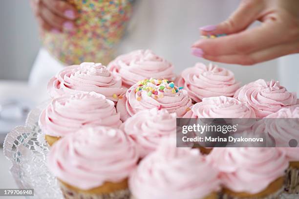 woman decorating cupcakes with sugar sprinkles - decorating a cake - fotografias e filmes do acervo