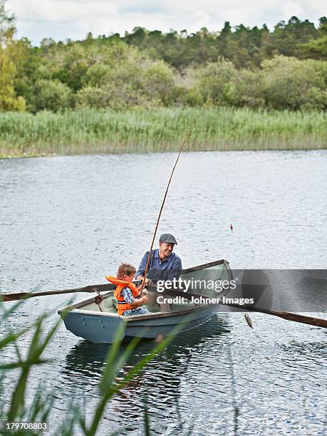 father with son fishing from rowing boat - rowboat bildbanksfoton och bilder