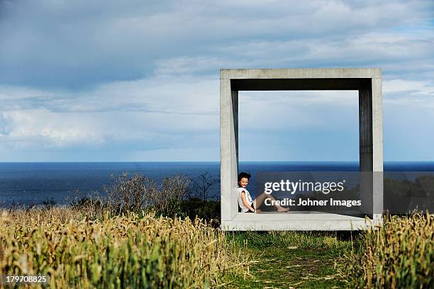 girl sitting in concrete square and looking at sea - svensk sommar bildbanksfoton och bilder