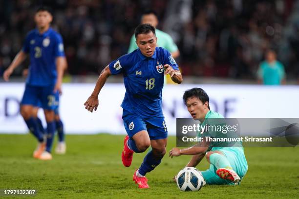 Chanathip Songkrasin of Thailand and Xie Pengfei of China compete for the ball during the FIFA World Cup Asian 2nd qualifier match between Thailand...