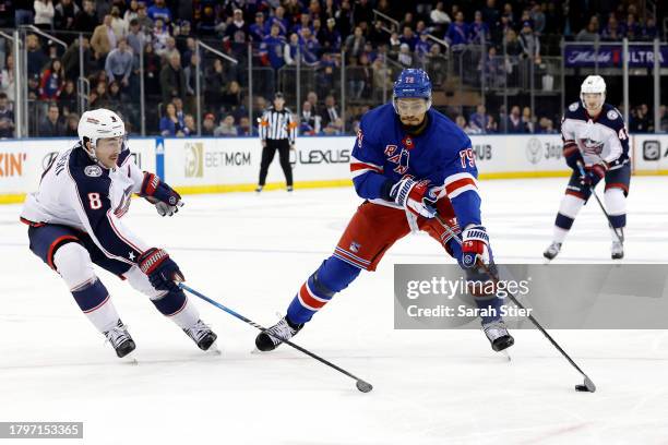 Andre Miller of the New York Rangers controls the puck as Zach Werenski of the Columbus Blue Jackets defends during overtime at Madison Square Garden...