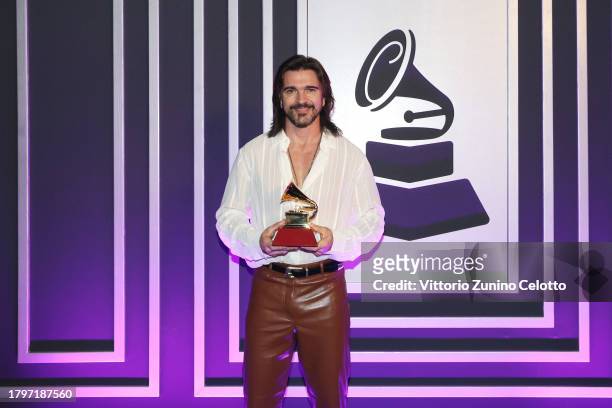 Juanes poses backstage with the award for Best pop/rock album onstage during the Premiere Ceremony for The 24th Annual Latin Grammy Awards on...