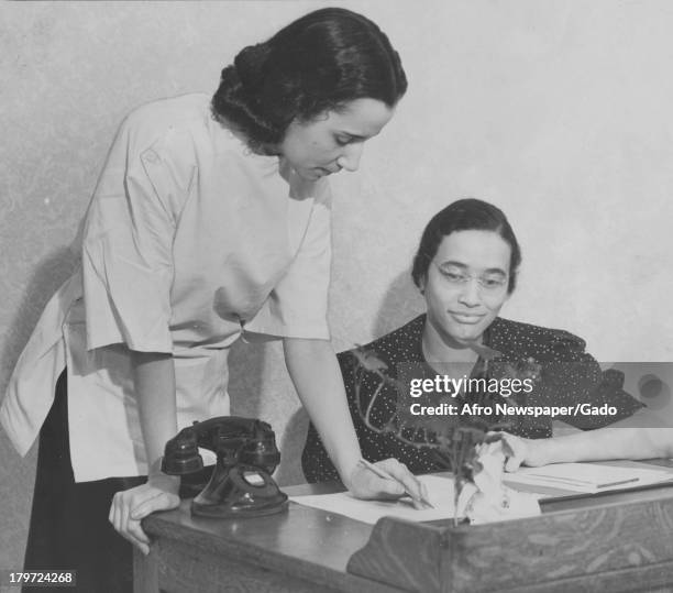 American medical practioner Dr Louise Young discusses plans with Miss Margaret Dorsey, secretary at maternity clinic, which opened this week at 1523...