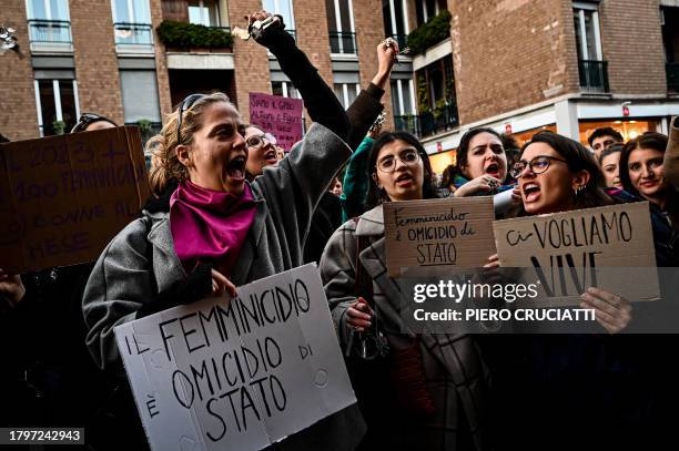 Protesters hold placards reading 'Femicide is a state homicide' and 'We want us alive' outside the University of Milan during a demonstration...