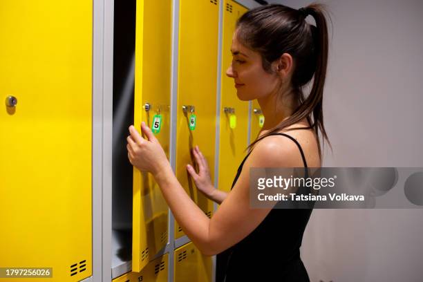 a woman selecting a new outfit in a dressing room, carefully choosing her attire with a sense of personal style - lock sporting position stock-fotos und bilder