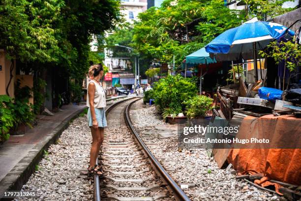 young woman walking along the train tracks in hanoi,vietnam - hanoi cityscape stock pictures, royalty-free photos & images