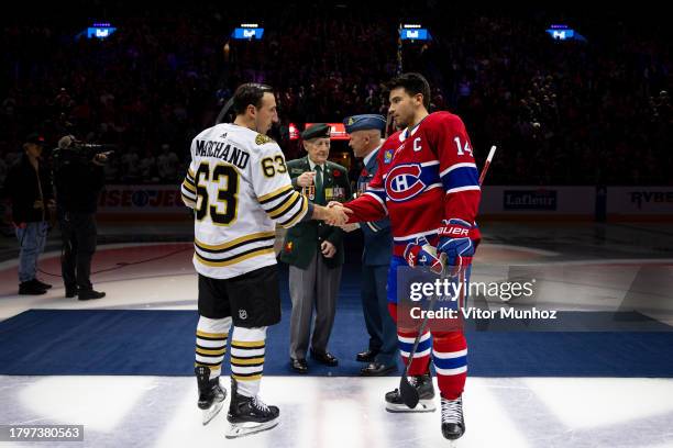 Team captains Brad Marchand of the Boston Bruins and Nick Suzuki of the Montreal Canadiens shake hands after the Ceremonial puck drop before the NHL...