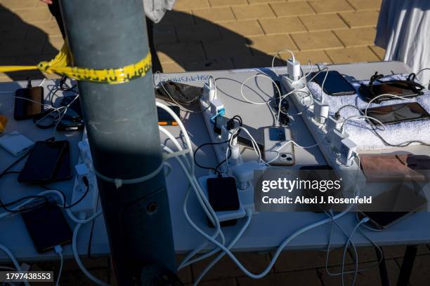 Power strips and phones rest on a table charging as families of the hostages, and their supporters, get ready before departing on Day 3 of the...