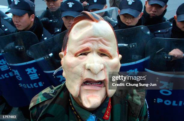 Wearing a mask representing U.S. President George W. Bush, a South Korean protester attends an anti-war rally near the U.S. Embassy February 14, 2003...