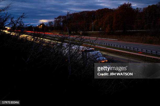 Headlights and taillights stream past as cars cross the Bay Bridge over the Chesapeake Bay in Stevensville, Maryland, on November 22, 2023 ahead of...