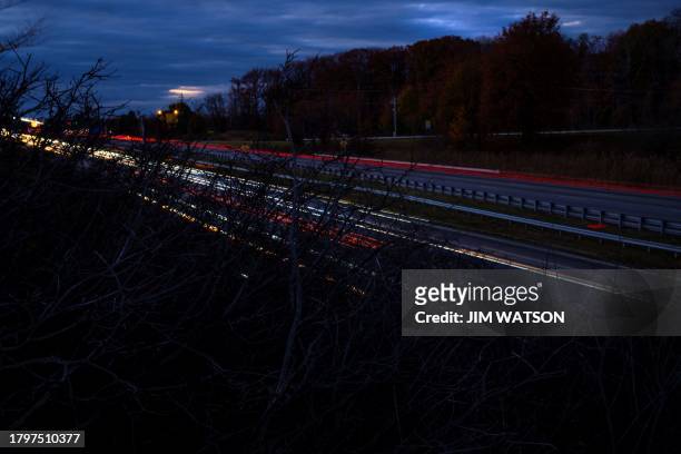 Headlights and taillights stream past as cars cross the Bay Bridge over the Chesapeake Bay in Stevensville, Maryland, on November 22, 2023 ahead of...