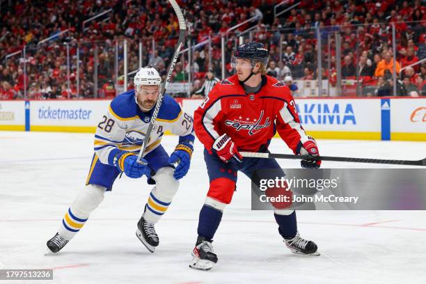 Rasmus Sandin of the Washington Capitals chases a loose puck as he is pressured by Zemgus Girgensons of the Buffalo Sabres during a game at Capital...