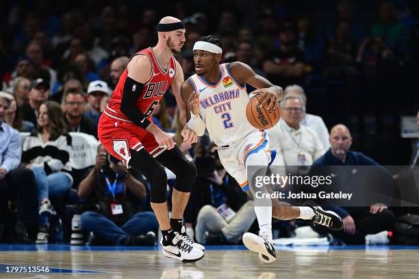 Shai Gilgeous-Alexander of the Oklahoma City Thunder attempts to drive past Alex Caruso of the Chicago Bulls during the first half at Paycom Center...