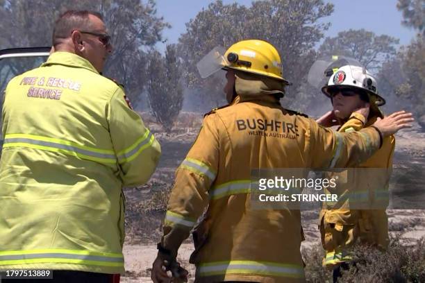 This frame grab taken from video footage provided by Australian Broadcast Corporation on November 22, 2023 via AFPTV shows bushfire fighters and...