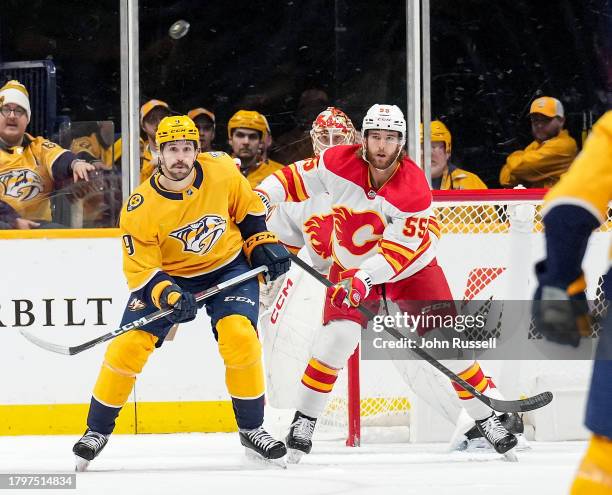 Filip Forsberg of the Nashville Predators battles in front of the net against Noah Hanifin of the Calgary Flames during an NHL game at Bridgestone...