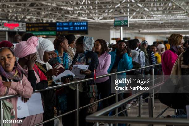 Travelers, primarily migrant workers, are waiting in line at the Bole International Airport in Addis Ababa, Ethiopia, on November 22 to board a plane...