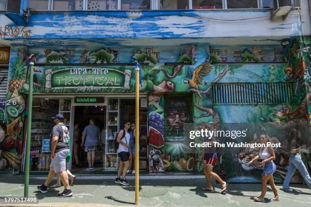 November 11 Rio de Janeiro, Brazil: The facade of a tourist shop in Lapa, Rio de Janeiro, showcases a vibrant mural of a Canindé macaw and sculptures...