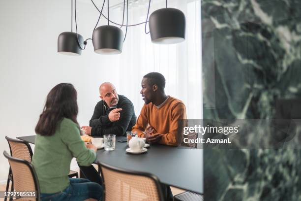 gemischtrassige freunde genießen eine tasse kaffee, während sie sich unterhalten - mixed race woman drinking tea stock-fotos und bilder