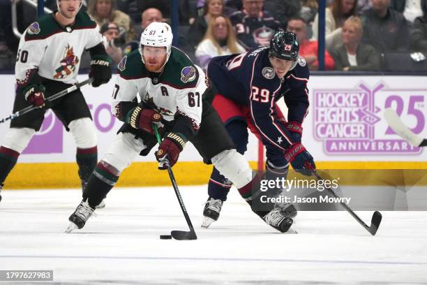 Lawson Crouse of the Arizona Coyotes battles Patrik Laine of the Columbus Blue Jackets for the puck during the first period at Nationwide Arena on...