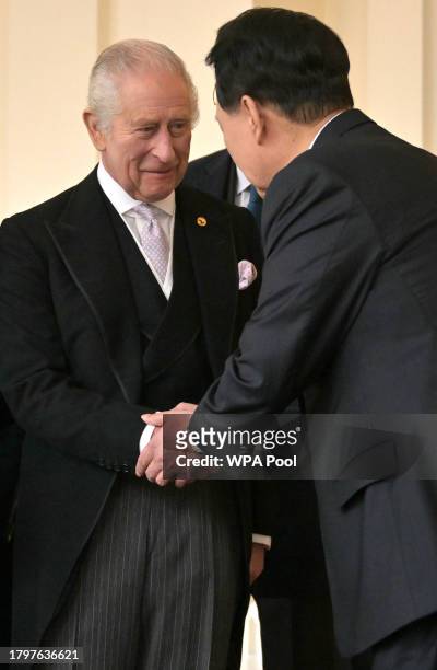King Charles III shakes hands with South Korean President Yoon Suk Yeol during a formal farewell at Buckingham Palace on the last day of the...