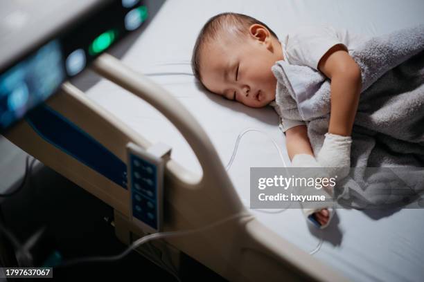 little asian boy patient with iv drip in hand - intoxicação alimentar imagens e fotografias de stock