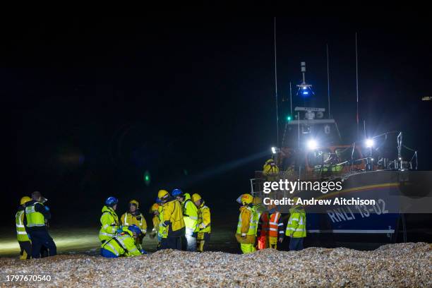 Coast Guard, Ambulance staff, Border Force and police escort asylum seekers who have just landed on Dungeness beach on an RNLI life boat late in the...