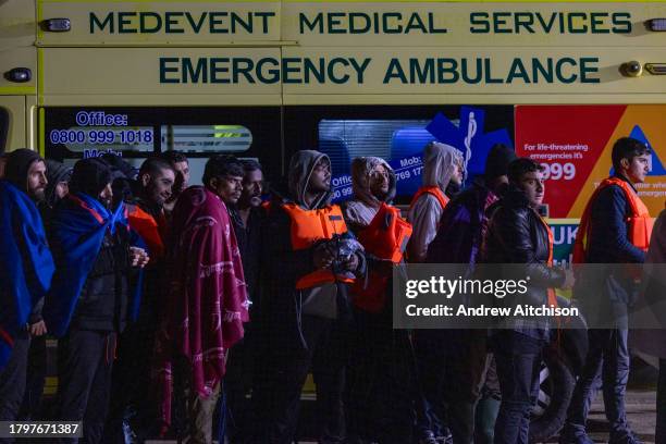 Coast Guard, Ambulance staff, Border Force and police escort asylum seekers who have just landed on Dungeness beach on an RNLI life boat late in the...