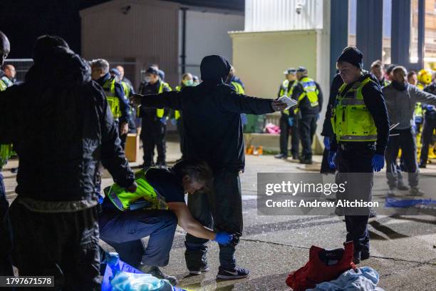 Coast Guard, Ambulance staff, Border Force and police escort asylum seekers who have just landed on Dungeness beach on an RNLI life boat late in the...